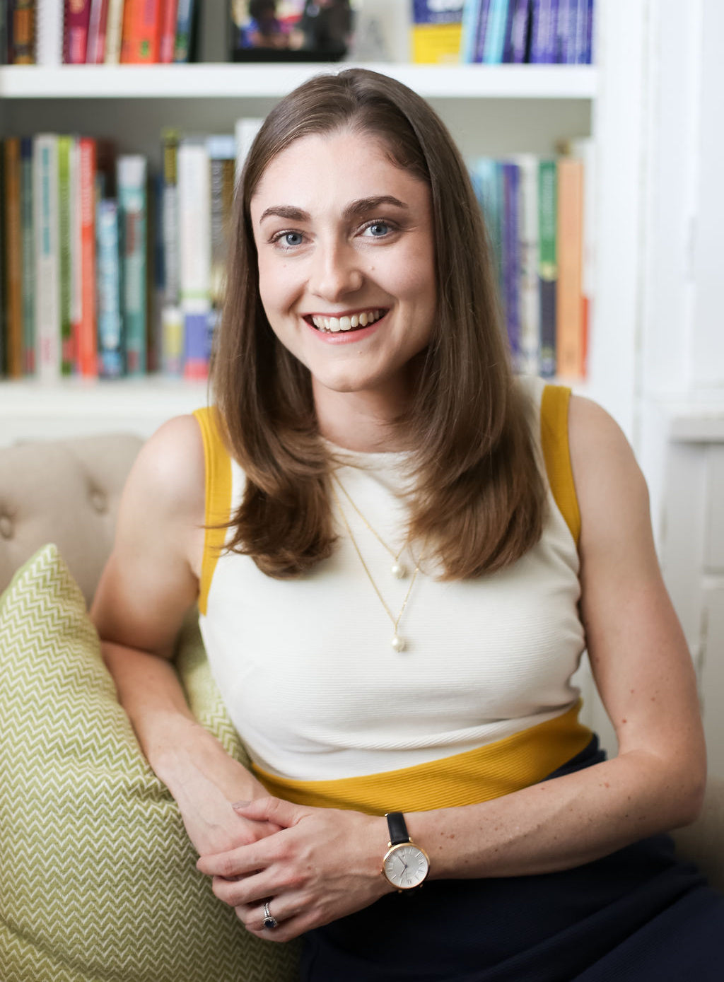 A photo of Alison Ryan, founder of Learning At The Primary Pond, sitting on a chair and smiling at the camera.