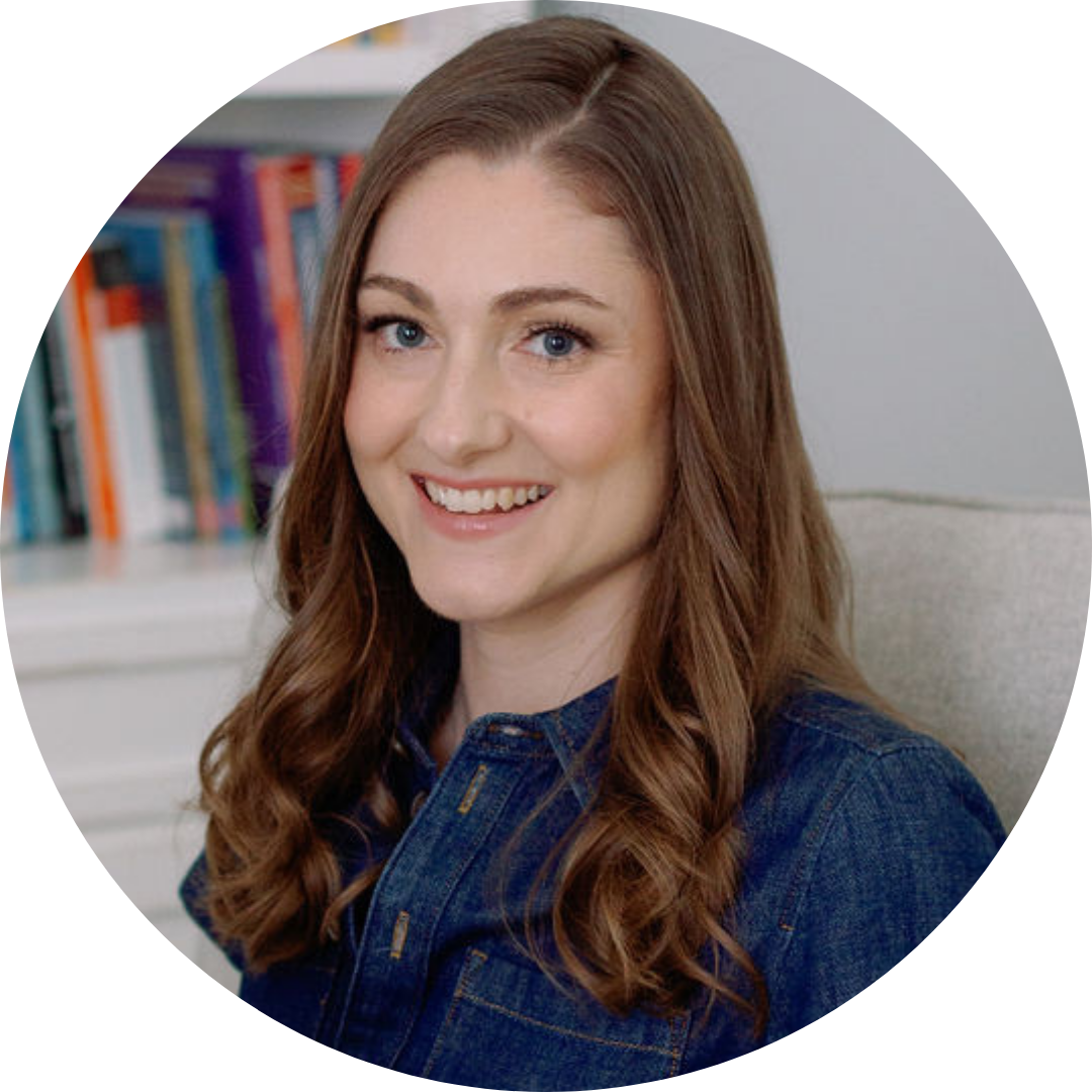 Woman with long brown hair wearing a denim jacket in a room with books. The woman is Alison Ryan, Founder and CEO of Learning At The Primary Pond.